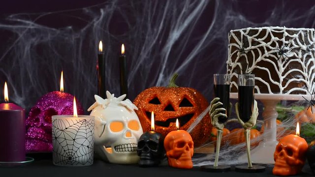 Spooky Halloween Party Table with chocolate spider cake and decorations, full table pan right.