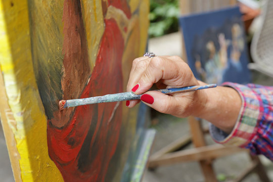femme senior artiste peintre peignant peinture à l'huile en extérieur