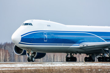Taxiing wide body cargo plane on the runway in a cold winter day