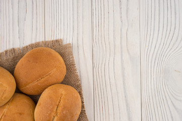 Hamburger buns on white old wooden table.