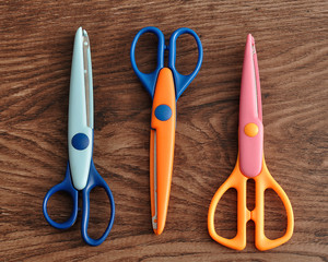 Colorful scissors isolated on a wooden background