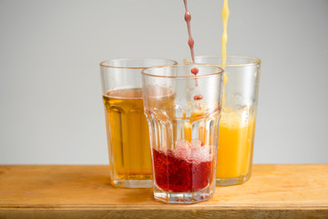 Glasses with apple, orange and cherry juice.