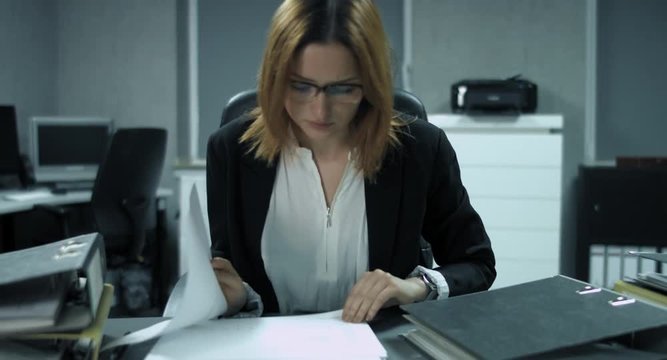 4K: Eine junge B&uuml;roangestellte &uuml;berarbeitet Dokumente um sie abzuheften. Die Hitze l&auml;sst ihre Konzentration schwinden.