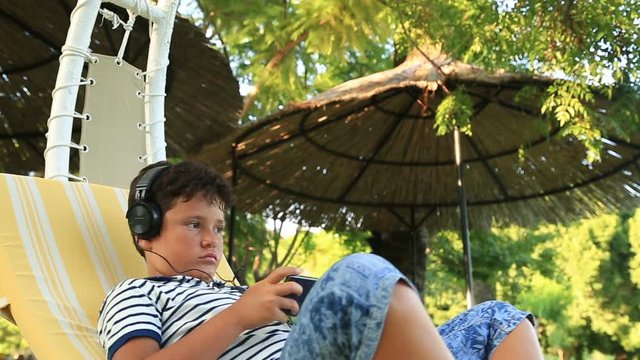 Young boy using mobil phone outdoor. Smartphone addiction