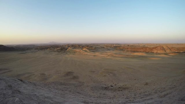 Colorful sunset over the Namib desert, Namib Naukluft National Park, Namibia, Africa. Clear sky, glowing rocks and hills, time lapse video.