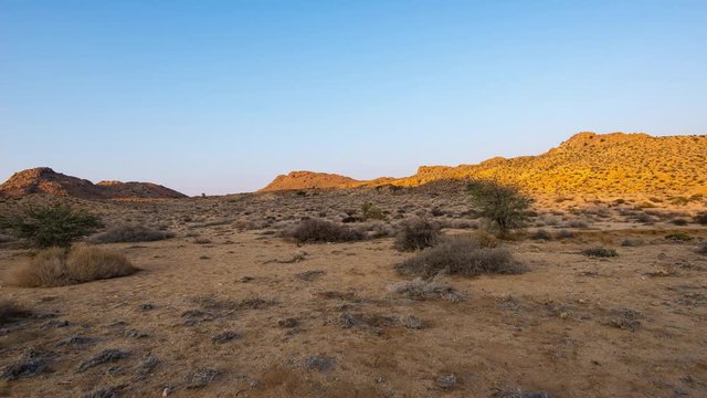 Colorful sunrise over the Namib desert, Aus, Namibia, Africa. Clear sky, glowing rocks and hills, time lapse video.