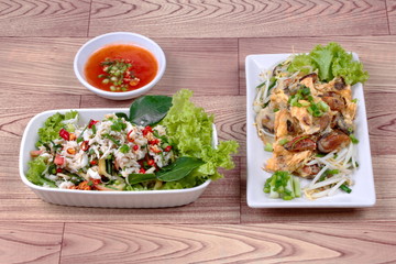 Fried oyster with herb and Spicy sour herb salad crab on brown.Side View  
