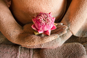 Lotus in the hands of sandstone Buddha.