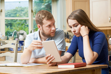 Male Home Tutor Helping Teenage Girl With Studies