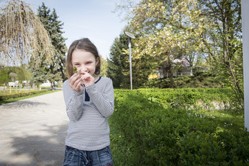 Fototapeta premium Little cute blonde girl having fun and enjoying a beautiful day in a park