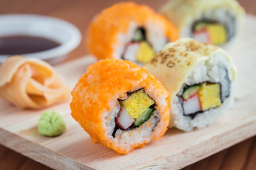 Sushi rolls on wooden plate