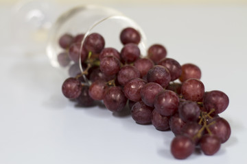 red grape in wine glass , red berry and wine glass on white background