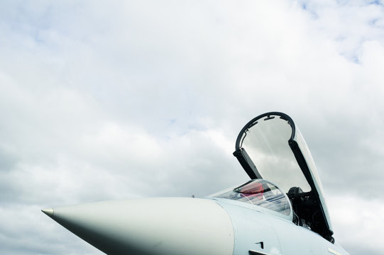 Detail Of Military Fighter Plane - Cockpit Of Airplane Is Open And Prepared For Pilot. Copy Space With Large Area Of Cloudy Sky