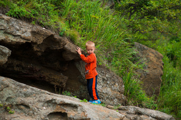 ребенок стоит на скале