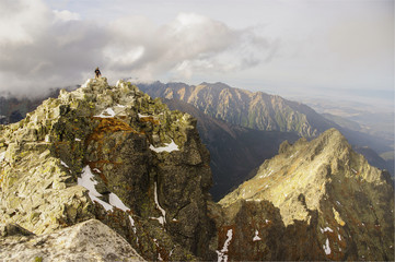 Beautiful mountain landscape. Single man stands on top of a mountain. Tatry. Rysy