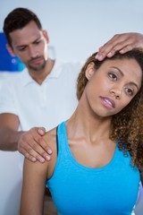 Physiotherapist giving neck massage to female patient