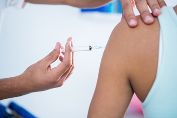 Physiotherapist injecting female patient