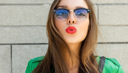 Pretty woman blowing lips kiss. Outdoors. Young  woman. Street f
