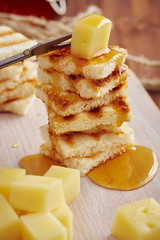 puouring honey on cheese and french toast for a sweet appetizer