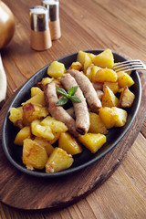roasted sausages and potatoes on a wooden table