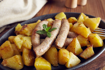 roasted sausages and potatoes on a wooden table