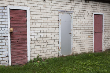 Three doors in the brick wall. Purple and gray.
