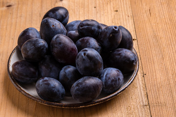 fresh plums on wooden table