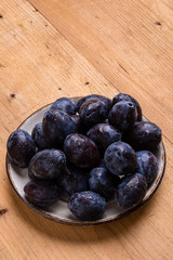 fresh plums on wooden table
