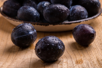 fresh plums on wooden table