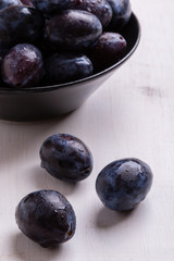 fresh plums on white table