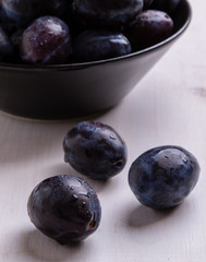 fresh plums on white table