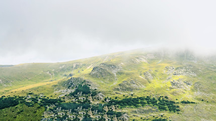 Transalpina road, Parang Mountains near clouds, hills with green grass and forests