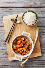 Baked chicken sesame on a bamboo chopping board with basmati rice