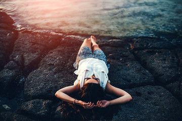 Fototapeta premium Pretty brunette girl relaxing in the stones