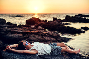 Pretty brunette girl relaxing in the stones