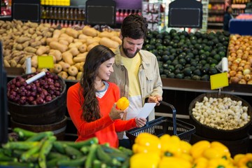 Couple checking their notepad while shopping in organic section