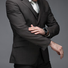 Business man sdusting of his sleeves, on a grey background, stock picture