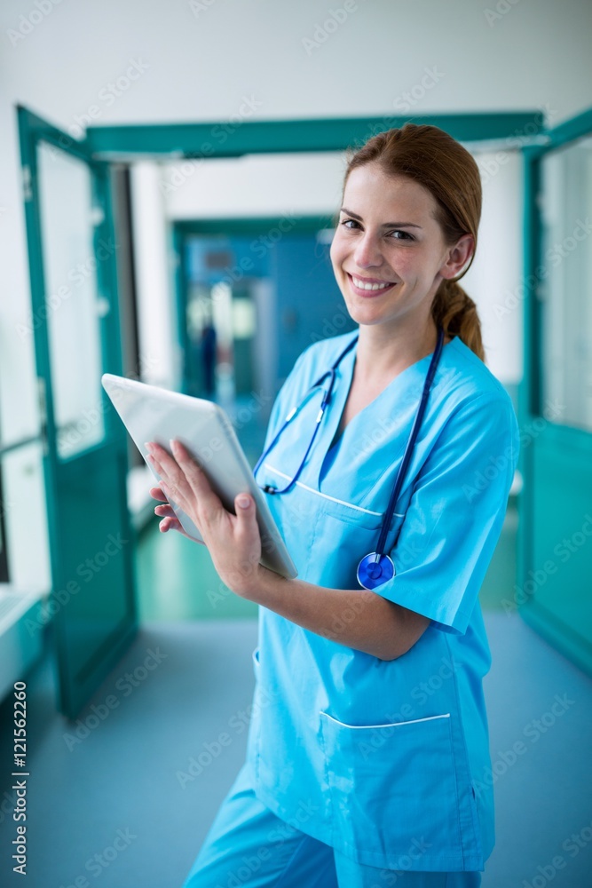Poster portrait of surgeon using digital tablet in corridor