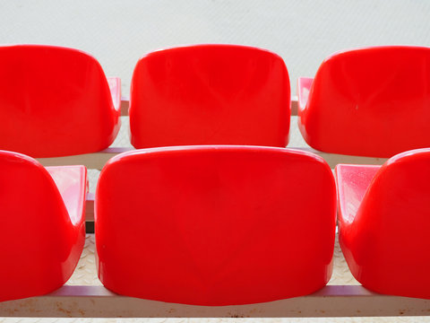 Red plastic armchairs on stadium