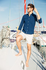 Young stylish sailor man standing on the yacht