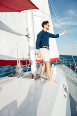 Young bearded man standing on a yacht