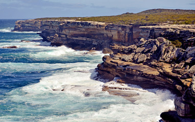 Weathered, rugged sandstone cliffs of Cape Solander, New South Wales coastline, Australia. Battered by wind and waves, rock collapse common.