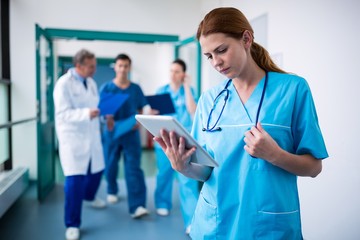 Surgeon using digital tablet in corridor