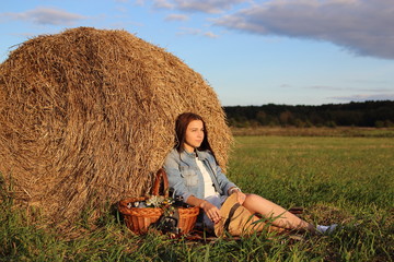 Naklejka na ściany i meble девушка с плетеной корзиной в поле у стога сена