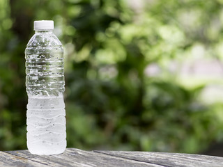 Bottle of cold fresh water on wooden table