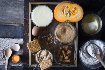 Ingredients for  pumpkin dump cake on the dark old background top view