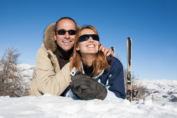 couple souriant à la neige