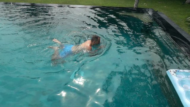Young man swimming in the pool, super slow motion 240fps
