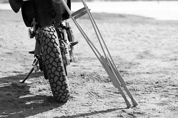 Motorcycle and crutches in black and white tone. Blurred backgro
