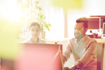 happy creative team with computer in office